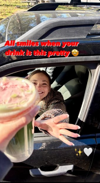 A delighted customer reaching out her car window for a pretty pink drink at Riverwoods Coffee